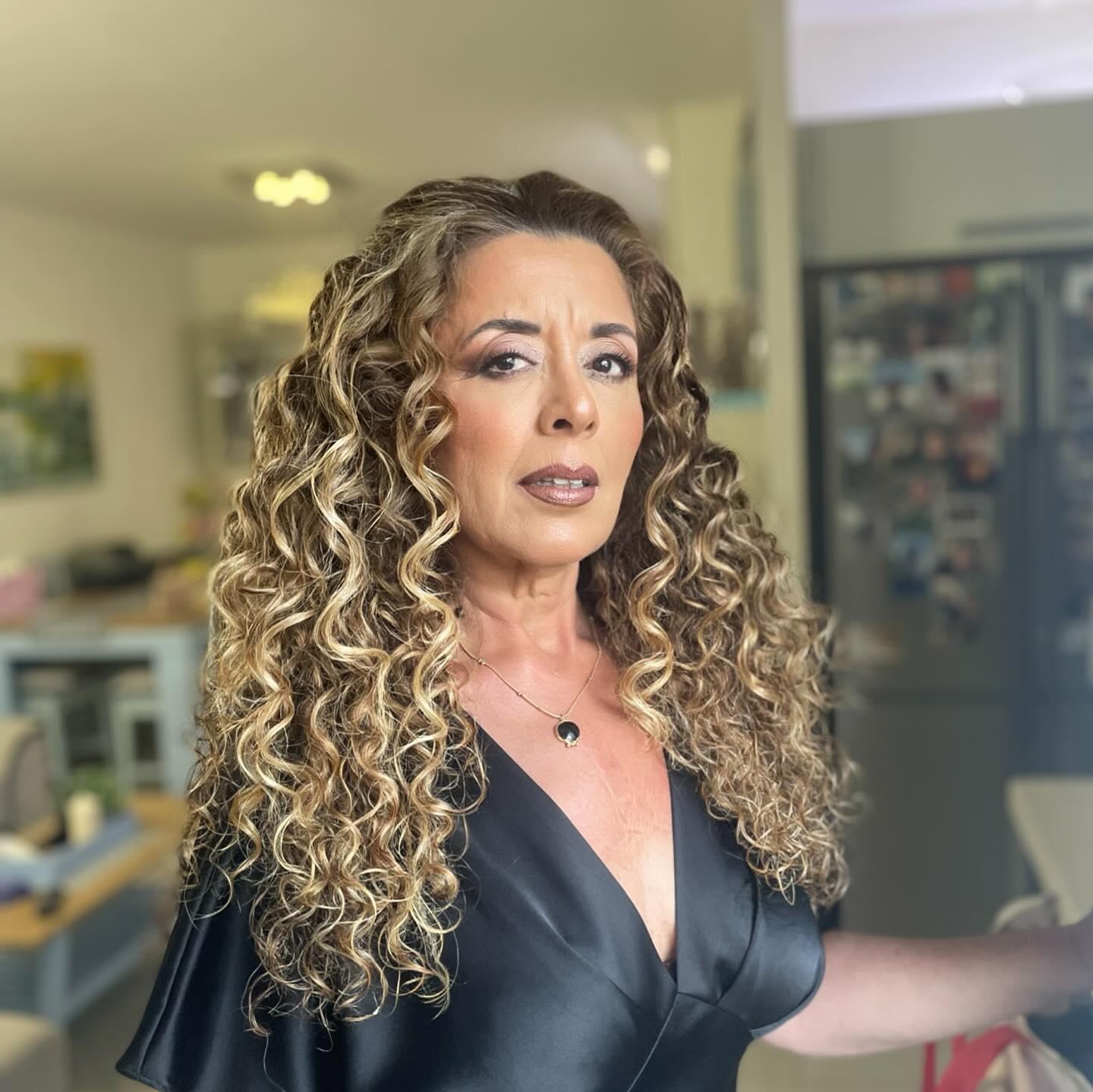 אישה עם איפור עדין ושיער מתולתל בהיר