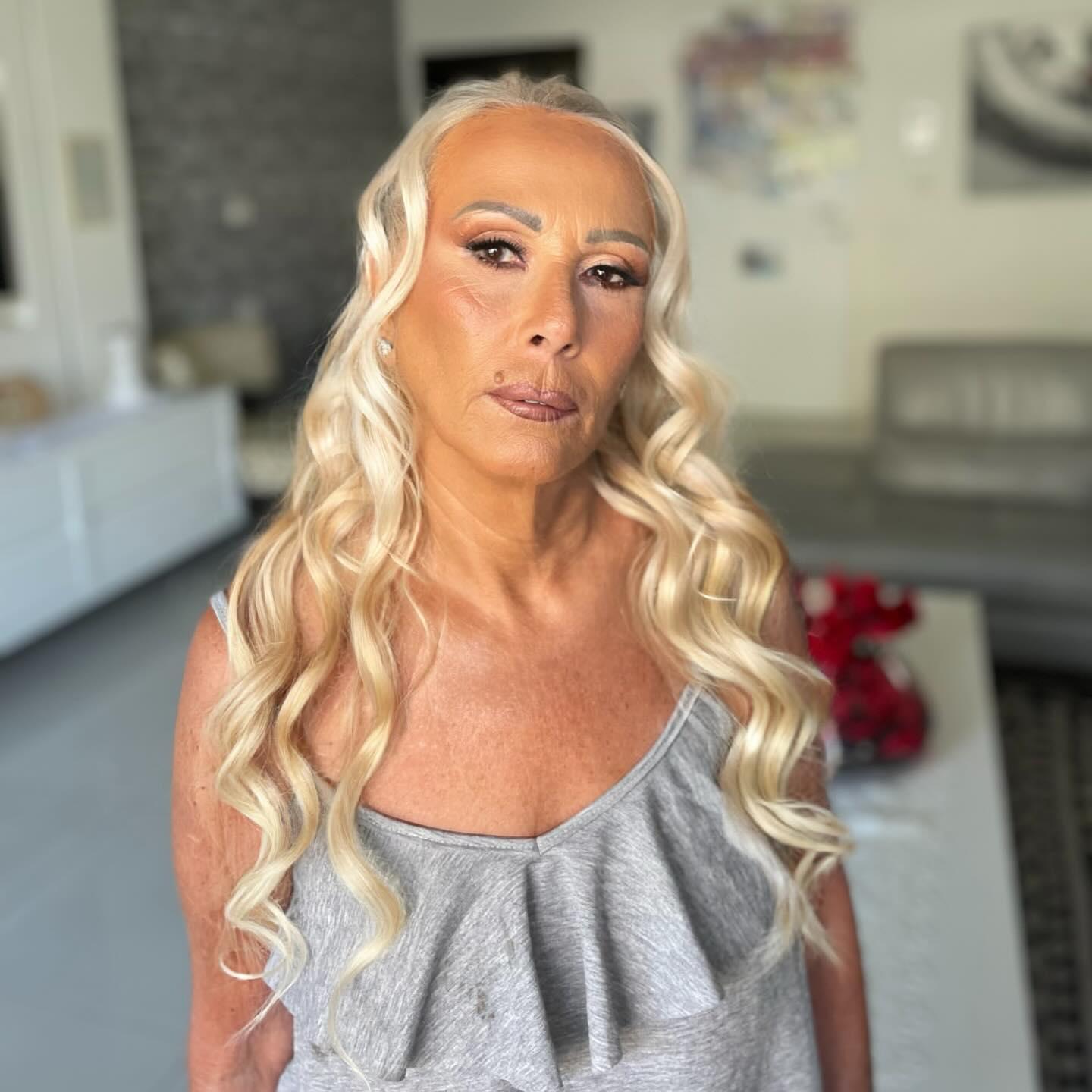 אישה בלונדינית עם איפור ערב ושיער ארוך מתולתל