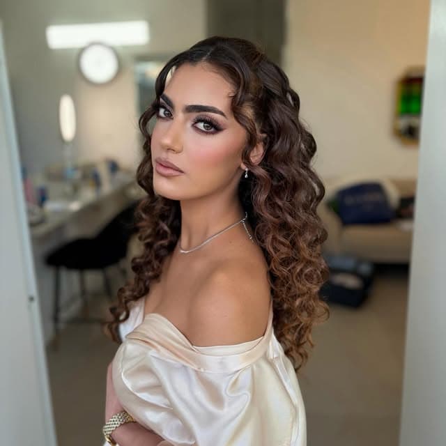 אישה עם איפור ערב ושיער מתולתל